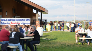 People gather at picnic tables outdoors in Kennewick at a past PSRW event