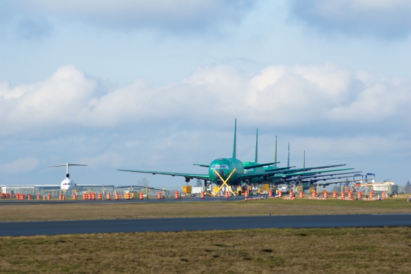 Jet planes in green wrappers lined up on a runway